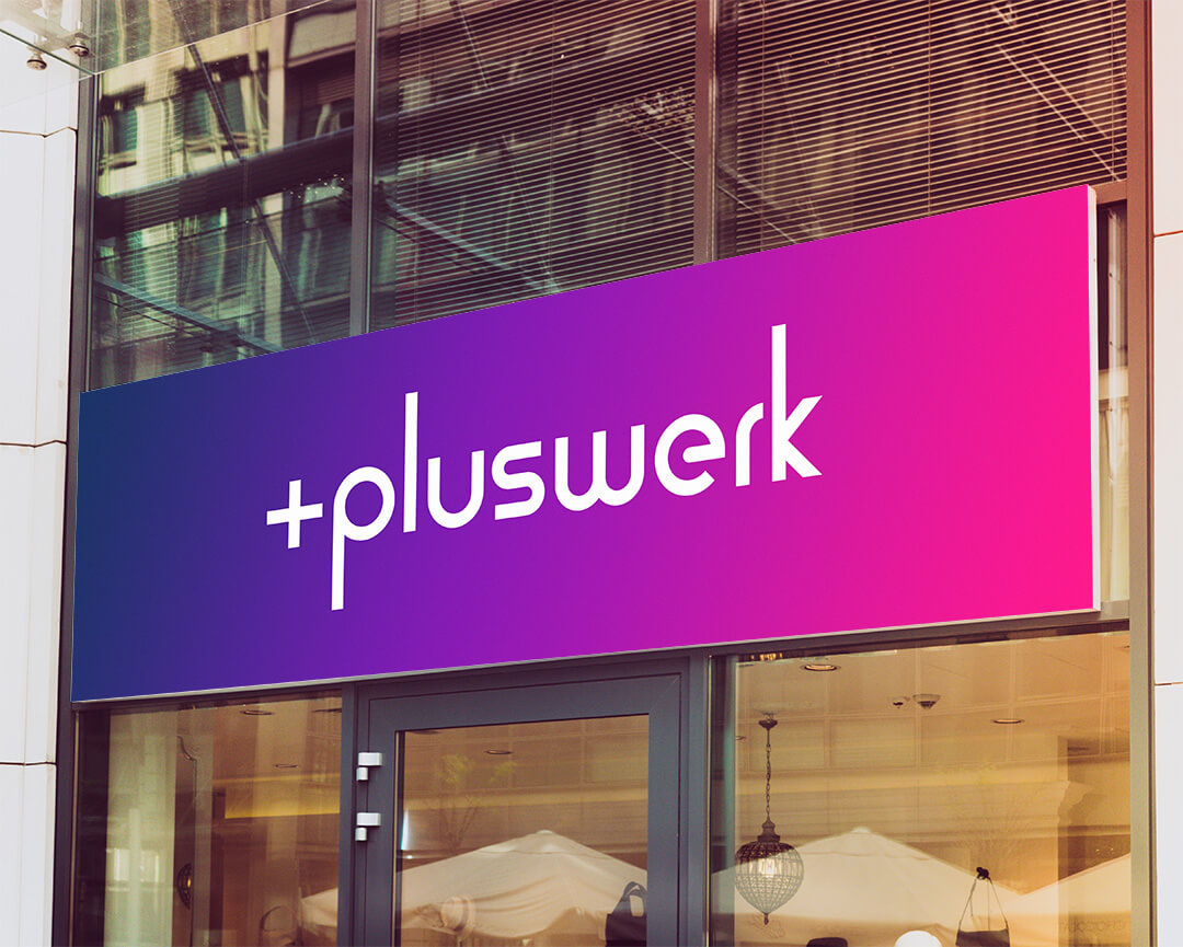 das neue Pluswerk Logo auf einem Schild über einem Eingang 